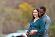 © PheelingsMedia - Interracial couple looking away enjoying pregnancy