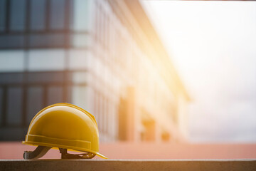 The concept of the construction industry Yellow engineer's hat with the morning light on a working day.
