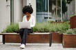 © fotofabrika - Young african american businesswoman working using laptop sitting on the bench in the city