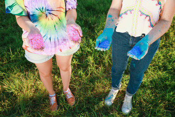 Wall Mural - Women with colorful powder dyes outdoors, closeup. Holi festival celebration