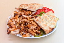 Turkish And Arabic Traditional Ramadan Chicken Doner Kebab With Tasty Tomato Sauce And Rice Or Turkish Pilav In White Plate On Wood Table Background. (Pilav Ustu Tavuk Doner)