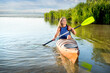 © pavlobaliukh - attractive woman paddling a kayak on a lake with reeds. A girl in a canoe on a water excursion, active pastime
