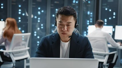 Wall Mural - serious face asian it developer administrator wearing headset speaker using laptop computer. server 