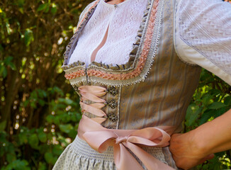 Wall Mural - a woman wearing a beautiful luxury traditional Bavarian or also Austrian dirndl dress (also called Tracht) and a gorgeous white lace blouse on a sunny summer day (Munich, Bavaria, Germany)	