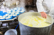 Cheesemaker pours the ricotta into plastic forms - process of making cheese in the workshop - dairyman puts hot ricotta cheese in plastic moulds – production fresh ricotta traditionally made at the da