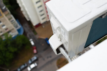 Close-up of pipe line to air conditioner exterior compressor.