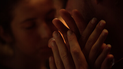 Closeup romantic lovers touch faces at night. Loving couple hold hands indoor