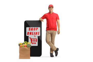 Wall Mural - Delivery man leaning on a big mobile phone with text shop online and and a grocery bag