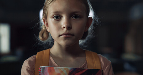 Upset girl holding notebook standing school hall closeup. Schoolgirl frightened 