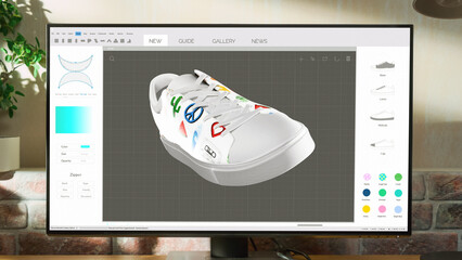 Poster - Desktop Computer Monitor Standing on a Table with 3D Design Softwear Processing a Model of Shoe. Cozy Empty Loft Apartment with Big Window with a Lamp, Notebook and Headphones on the Table.