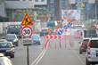 © bilanol - Roadworks warning traffic signs of construction work on city street and slowly moving cars