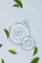 Wall Mural - Organic cosmetic background clean transparent waves, water splashes with green leaves