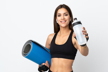 Poster - Young sport woman isolated on white background with sports water bottle and with a mat