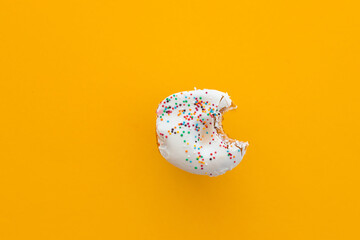 Close up donut with bite missing isolated on color background