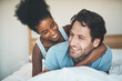 © Allistair/peopleimages.com - Interracial, playful and loving couple cuddling in bed and enjoying the weekend together at home. Affectionate, happy and bonding diverse lovers embracing and having fun in their bedroom