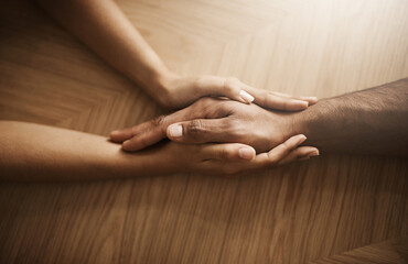 Love, support and care with people holding hands at a table, talking, bonding and showing affection. Couple having a discussion about relationship. Woman helping husband with his mental health