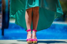 Woman wearing a turquoise dress and pink shoes