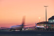 © Chalabala - Airplane in blurred motion. Traffic at airport during colorful sunrise..