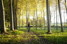 Teenage Girl Standing On A Footpath In A Forest Glade, France