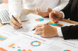 © Thapana_Studio - business teamwork Calculating Profit and Cost with Calculator, Growth Chart Analysis and Investing ,Business planning and strategies to maximize sales profits, long-term plans.