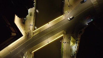 Canvas Print - Urban aerial top view of an illuminated bridge during nighttime