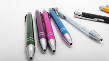 Closeup Shot Of A Row Of Different-colored Pens On A White Table