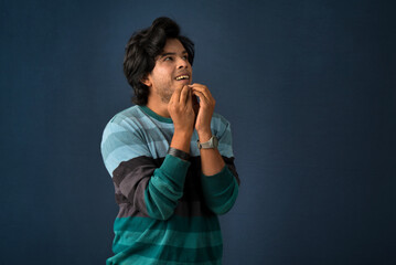 Wall Mural - Portrait of a young man thinking on a dark background