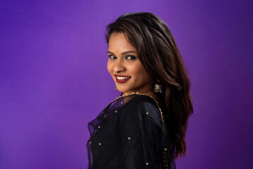 Portrait of a young girl or woman posing on purple background