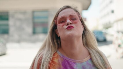 Sticker - Young woman wearing heart sunglasses kissing at street