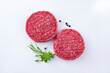 Rohe Barbecue Rindfleisch Hamburger Patty mit Kräuter und Gewürzen angeboten als Draufsicht auf weißem Hintergrund mit Textfreiraum