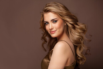 beautiful glamorous model woman with long wavy and shiny hair against brown studio wall banner backg