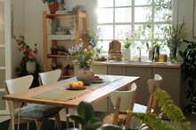 Four Chairs Surrounding Wooden Table With Fresh Apples, Bunch Of Wildflowers In Vase, Homemade Cookies And Linen Napkins
