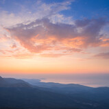 Fototapeta Las - mountain ridge silhouette above sea bay at early morning