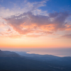 mountain ridge silhouette above sea bay at early morning