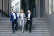 © Liubomir - Diverse business team man and woman walking together on stairs outside office building, business people take a walk on break and have fun talking