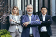 Portrait of serious diverse business team, employees with boss together looking at camera seriously and thoughtfully, group of business people outside office in business suits