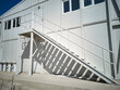 Metal stairway outside of mobile industrial building. Newly built two-storey prefabricated industrial building. Prefabricated office container building at construction site