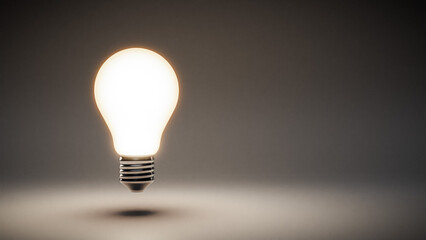 Glowing lightbulb on gray background