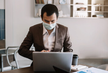 Business men working laptop computer and holding smartphone with coffee cup on table in coffee shop or cafe, working from cafe, freelance work concept.