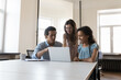 © fizkes - Three multiethnic teammates look at laptop screen prepare on-line presentation, working on corporate task, share skill and thoughts, analyse sales report, search solution. Business, teamwork concept