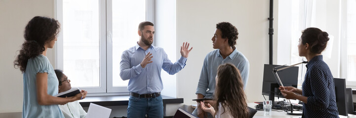 Canvas Print - Panoramic image diverse employees take part in group meeting in modern co-working office. Multi ethnic business people, colleagues, workmates brainstorming, listen to project leader or company boss