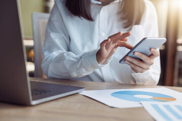 Close up of businesswoman hands using phone while sit on her workplace in office