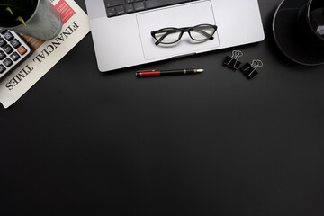 Flat lay of top view desk work table with computer laptop and financial newspapaer in Money financial concept includes copyspace for add text or graphic