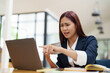 © Jirapong - Asian businesswoman taking a coffee break while using a computer