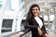 © Atstock Productions - Cheerful smiling Hispanic woman in business suit standing outdoors in the city