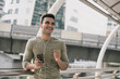 © Atstock Productions - Happy handsome Indian man wearing earphones listening to streaming music on smartphone in the city
