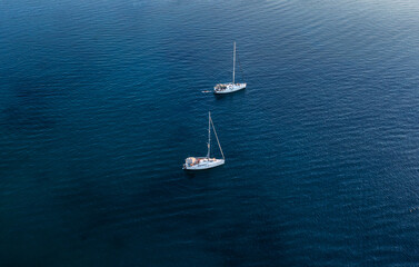 Wall Mural - Travel, vacation background. Aerial drone view of sailing boats in the blue clear sea on a summer day. Peaceful seascape. Beautiful calming landscape