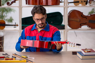 Wall Mural - Young man repairing musical instruments at workshop