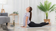 © Pichsakul - Yoga exercise concept, Asian woman doing yoga with lying in cobra pose and watching tutorial online