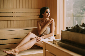 Wall Mural - Young woman relaxing in the sauna